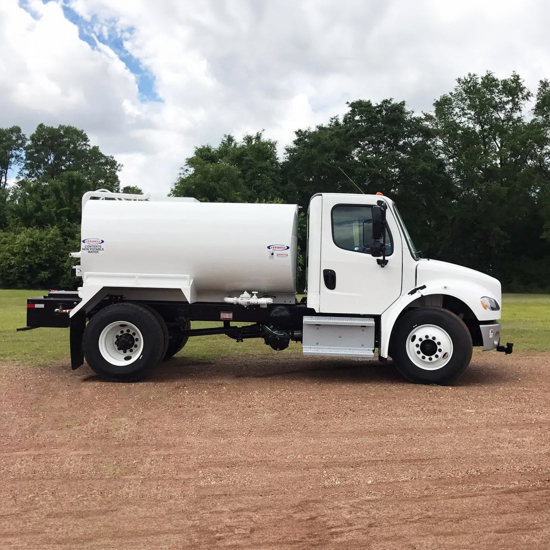 2,000-gallon water truck, with robust tank and spray nozzles, designed for dust suppression and water transport on construction sites.